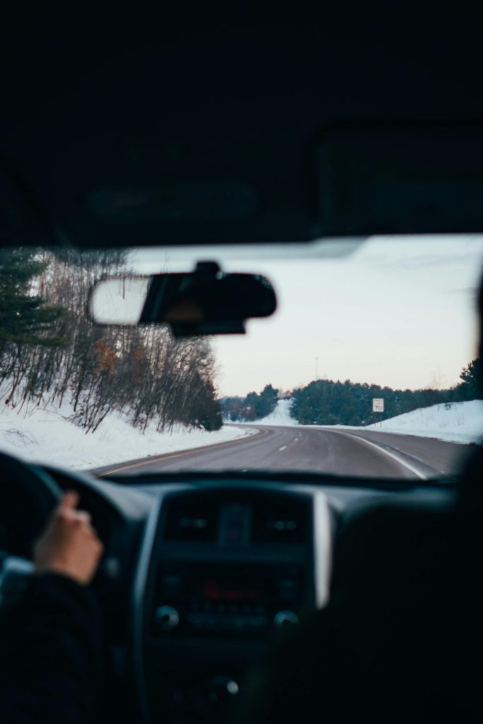 pexels photo 1986119 1986119 Driving along a snowy highway in winter, capturing the serene landscape and vehicle interior view.